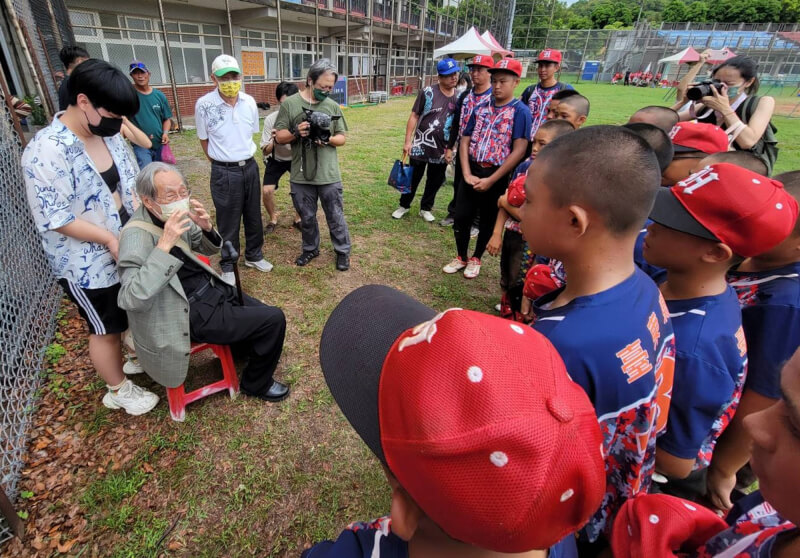 圖為去年蔡焜霖（左2坐者）在台東舉辦的耕元盃棒球賽現場，為紅葉小將加油打氣。（中央社檔案照片）