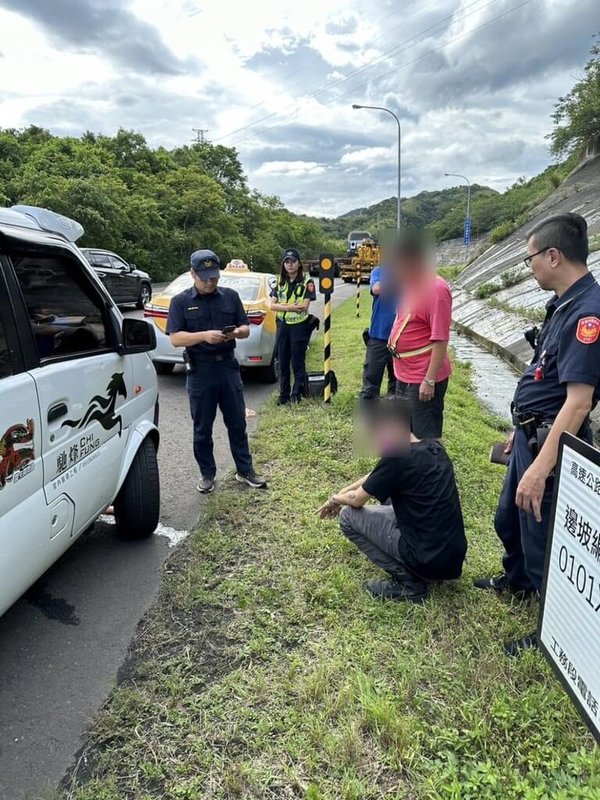 39歲張姓男子(蹲坐者)5日在基隆長庚醫院偷走計程車後,行駛在國道1號與小貨車發生擦撞逃逸,隨即又被小貨車追趕攔下,張男與對方口角後意圖再搶奪小貨車逃逸,所幸警方及時到場逮捕張男,全案詢後將依竊盜、強盜罪嫌送辦。(讀者提供)中央社記者王朝鈺傳真 112年9月5日