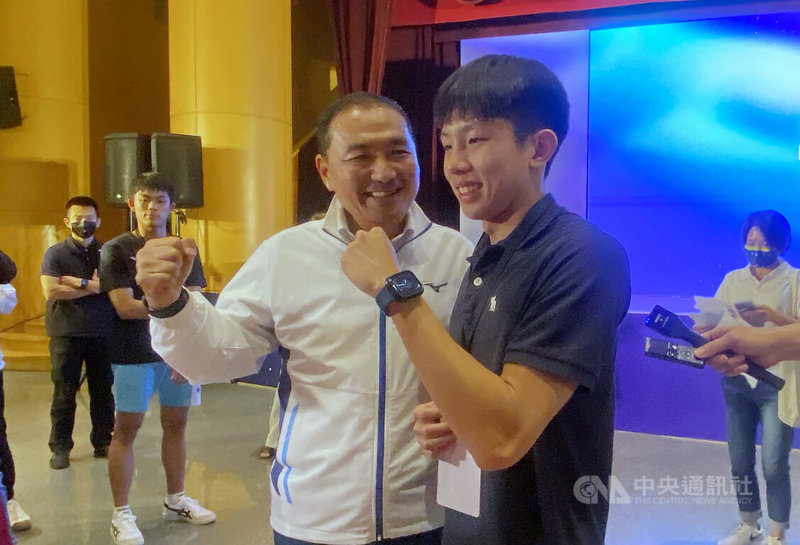 新北市政府7日表揚體育有功人員與單位,其中卓承齊和卓沛齊(前右)兄弟檔都是游泳健將,市長侯友宜(前左)出席頒獎後,也與代替游泳選手卓承齊領傑出運動員獎的弟弟卓沛齊互動問候近況。中央社記者黃旭昇新北攝 112年9月7日
