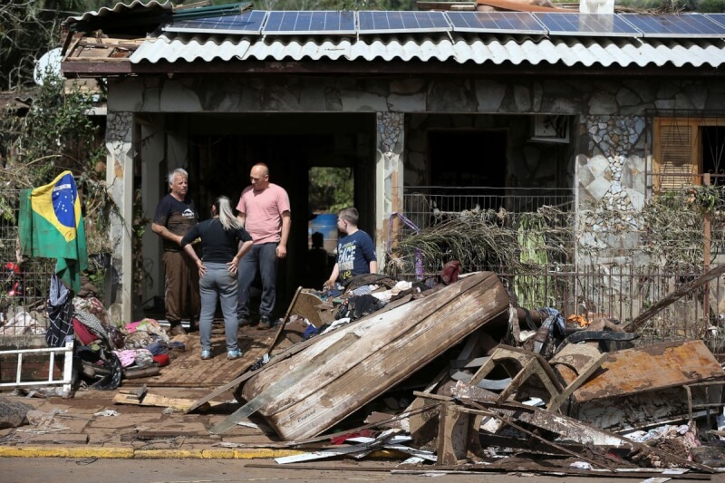 巴西南大河州民眾6日清理遭暴雨侵襲後的家園。（路透社）