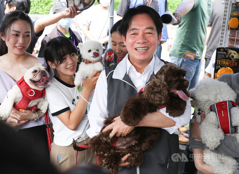 民進黨總統參選人賴清德（前右）9日在台北出席全國幸福寵物產業賴清德後援會成立大會，參觀現場攤位時，抱著毛小孩拍照留念。中央社記者謝佳璋攝 112年9月9日