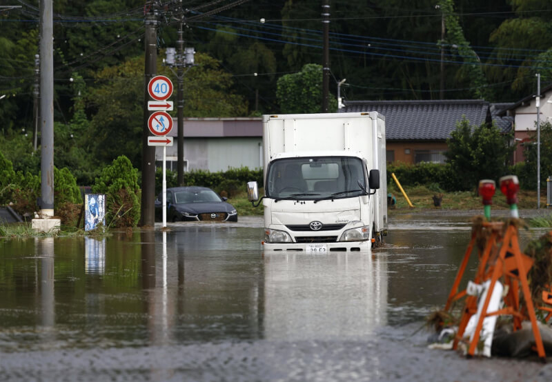 圖為千葉縣茂原市8日道路水淹成河。（共同社）