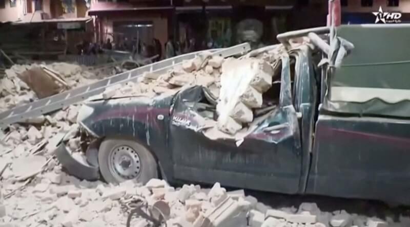 摩洛哥當地電視台畫面拍下因8日強震毀損的建物及車輛。（Al Oula TV/Handout via 路透社）