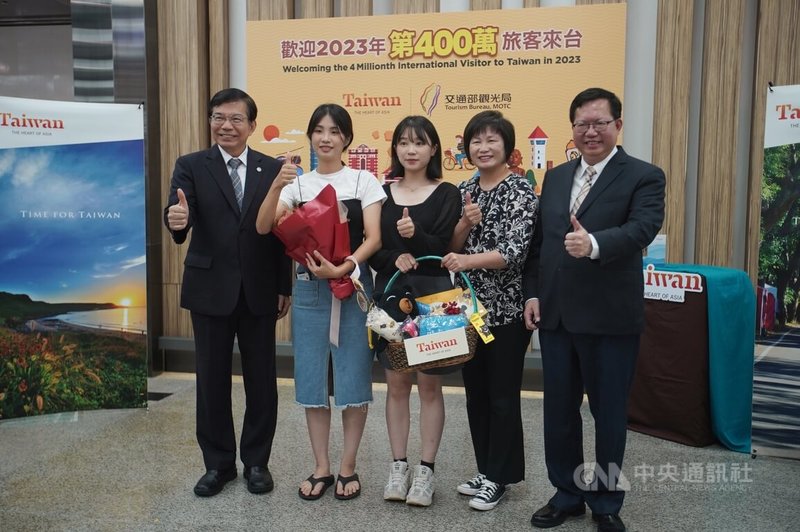 行政院副院長鄭文燦(右1)、交通部長王國材(左1)13日在台北松山機場國際線入境大廳出席2023年第400萬名來台旅客迎賓活動,送上禮物及獻花給來自韓國的旅客。中央社記者徐肇昌攝 112年9月13日