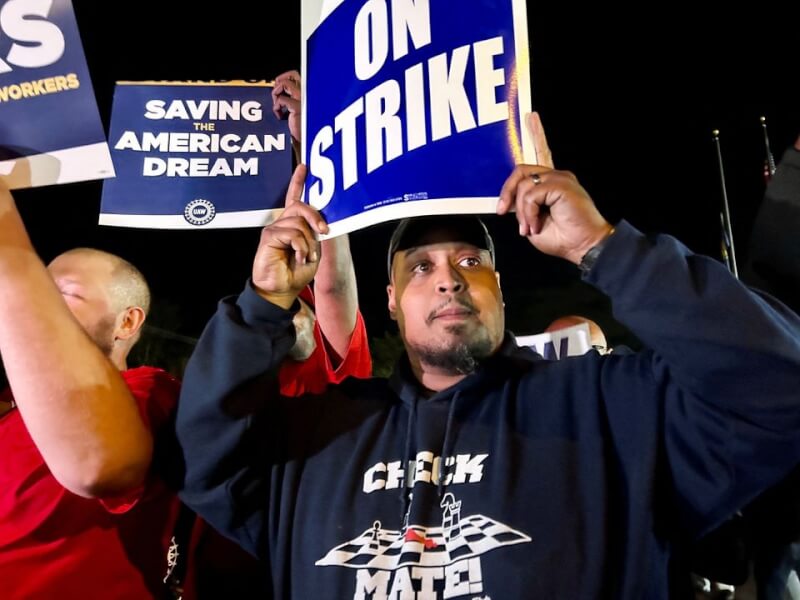 美國汽車工人工會15日在密西根州韋恩市的福特工廠舉起標語罷工。（路透社）