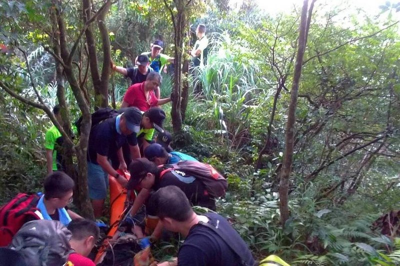 一名年約40歲的男性登山客16日攀登基隆市姜子寮山時，疑因中暑意識不清，消防局獲報派員協助，眾人合力用擔架將男子搬運下山送醫。（基隆市消防局提供）中央社記者沈如峰基隆傳真  112年9月16日