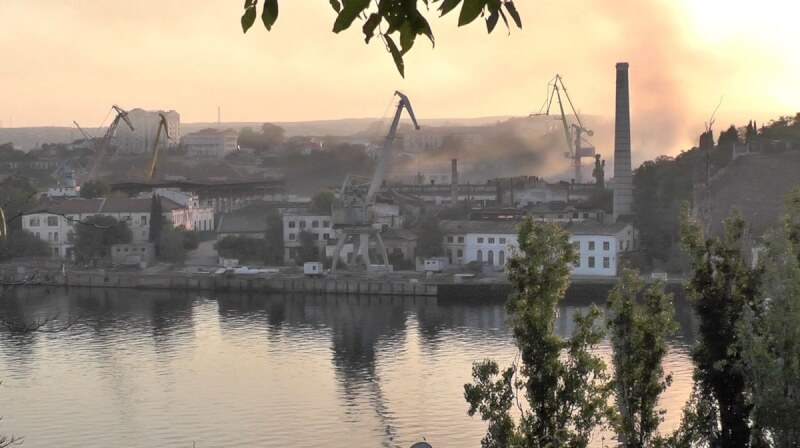 圖為13日克里米亞造船廠遭烏克蘭導彈襲擊後冒出濃煙。（路透社）