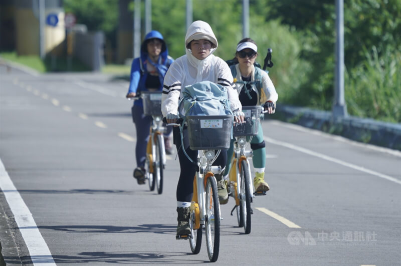 圖為台北市北投區自行車道上，不少民眾穿起防曬外套、頂著豔陽騎乘單車。（中央社檔案照片）