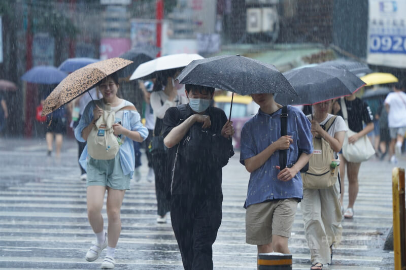 圖為民眾在台北市中正區撐傘過馬路。（中央社檔案照片）