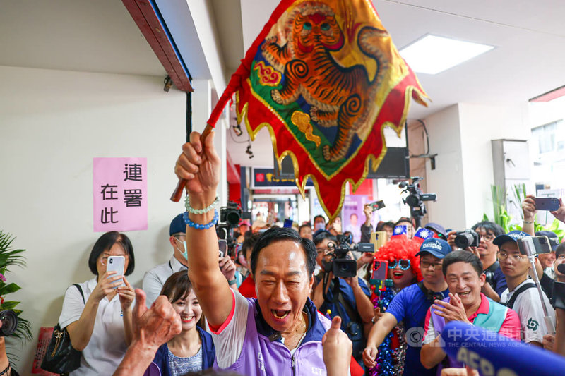 為爭取獨立參選2024總統、副總統資格，鴻海創辦人郭台銘（前中）與搭檔賴佩霞的連署站點陸續成立，郭台銘20日到新北市板橋區的連署站高舉虎旗，向支持者致意並開心高呼「進攻」。中央社記者王騰毅攝　112年9月20日