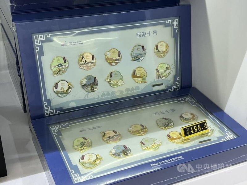 杭州亞運23日開幕,位於主媒體中心紀念品商店所販售部分周邊商品都融入當地特色,例如:結合西湖十景樣式的紀念徽章。中央社記者黃巧雯攝 112年9月22日