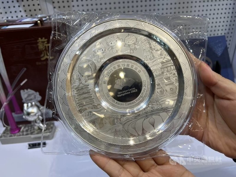 杭州亞運23日開幕,位於主媒體中心紀念品商店販售部分周邊商品融入當地特色,例如:印有雷峰塔等杭州造景的銀盤。中央社記者黃巧雯攝 112年9月22日