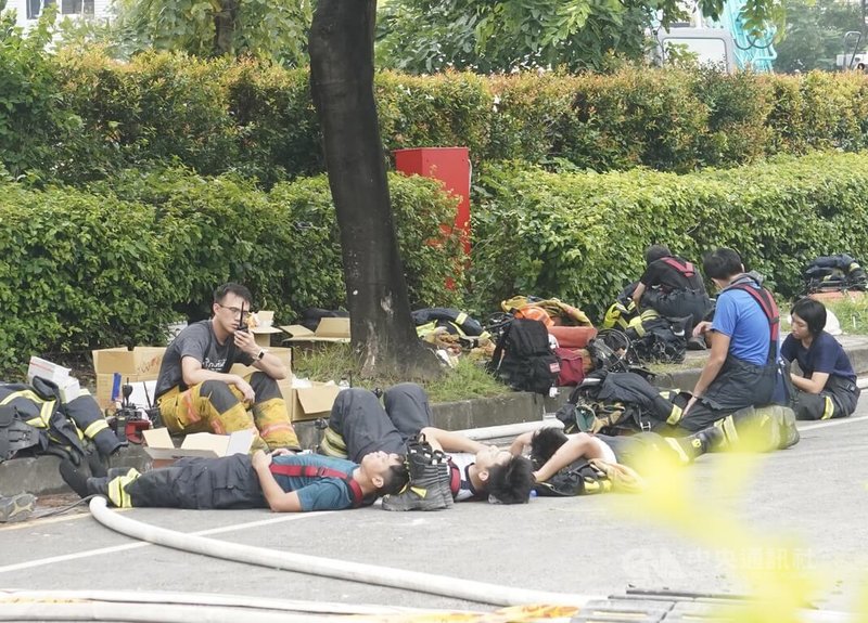 屏東科技產業園區明揚國際科技公司發生大火，消防員趕抵現場，22日傍晚至23日展開救援，幾乎沒有時間睡覺。圖為消防員卸下部分裝備，累癱席地休息。中央社記者董俊志攝  112年9月23日