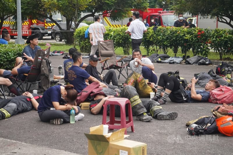 屏東科技產業園區明揚國際科技公司22日發生火警，第一線消防人員徹夜救火，幾乎沒有時間休息。有消防員23日暫時卸下裝備，疲憊不堪席地而睡。中央社記者董俊志攝 112年9月23日