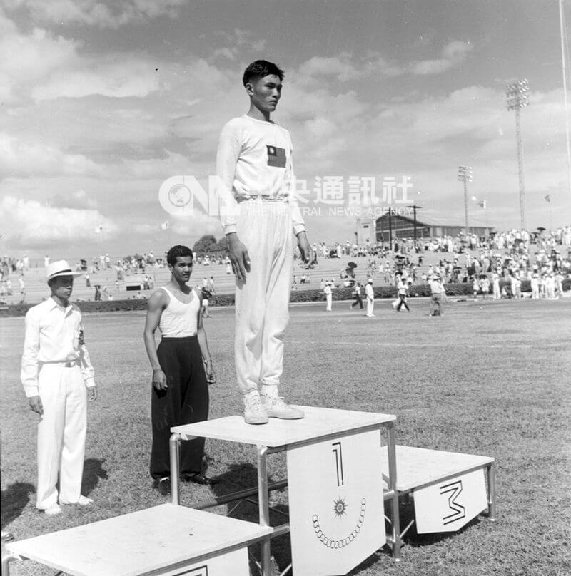圖為1954年亞運大會透過麥克風介紹奪金牌的楊傳廣時，他第一個站上獎台，接受觀眾的鼓掌與喝采。（中央社檔案照片）