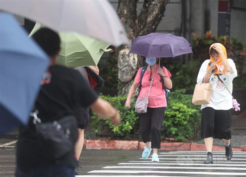 圖為北市大安區街頭民眾撐傘遮擋雨勢。（中央社檔案照片）
