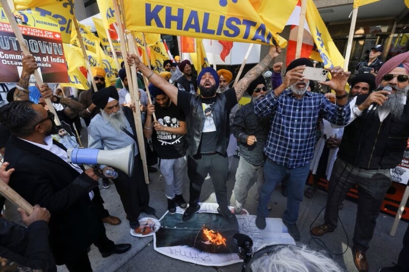 錫克教抗議者25日在印度駐加拿大使領館外抗議，將印度總理莫迪的肖像踩在腳下並焚燒旗幟。（路透社）