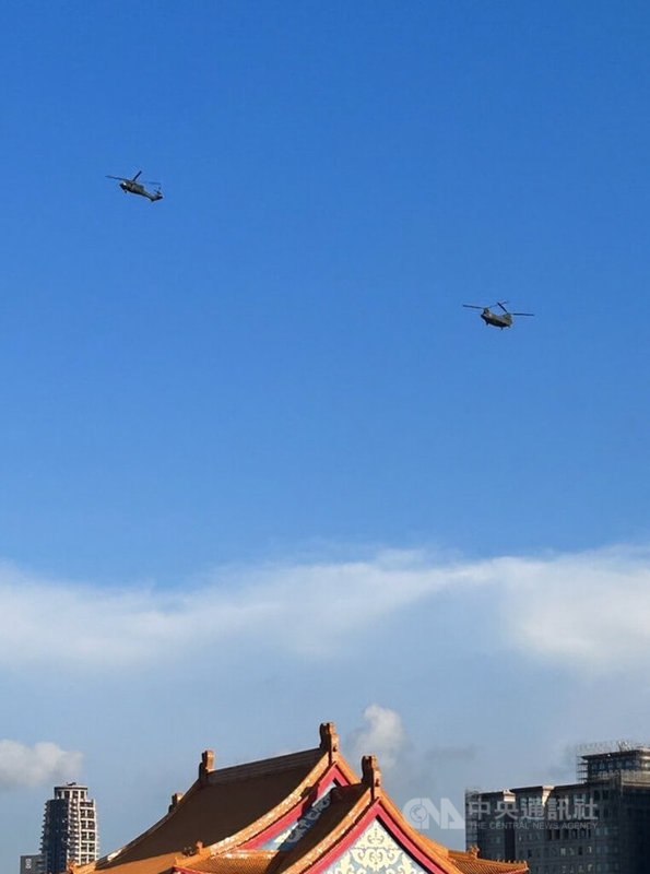 國慶將至，國軍26日進行半兵力預演，其中1架UH-60M黑鷹直升機（左）與游懸掛巨幅國旗的CH-47SD契努克運兵直升機（右）通過總統府上空。中央社記者游凱翔攝  112年9月26日