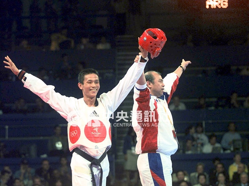 2000年雪梨奧運黃志雄（左）敗部復活，踢下戰勝阿根廷選手塔拉布拉禮，獲得銅牌。圖為黃志雄在比賽結束後與教練宋景宏（右）一同向觀眾揮手致意。（中央社檔案照片）