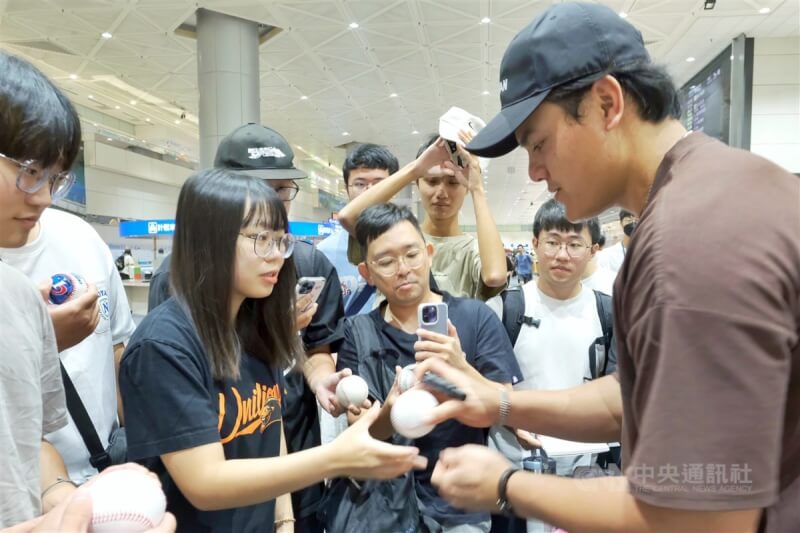 旅美棒球好手張育成(右)27日清晨搭機返台,吸引不少球迷到桃園國際機場接機,張育成也一一為球迷們簽名並合影。中央社記者吳睿騏桃園攝 112年9月27日