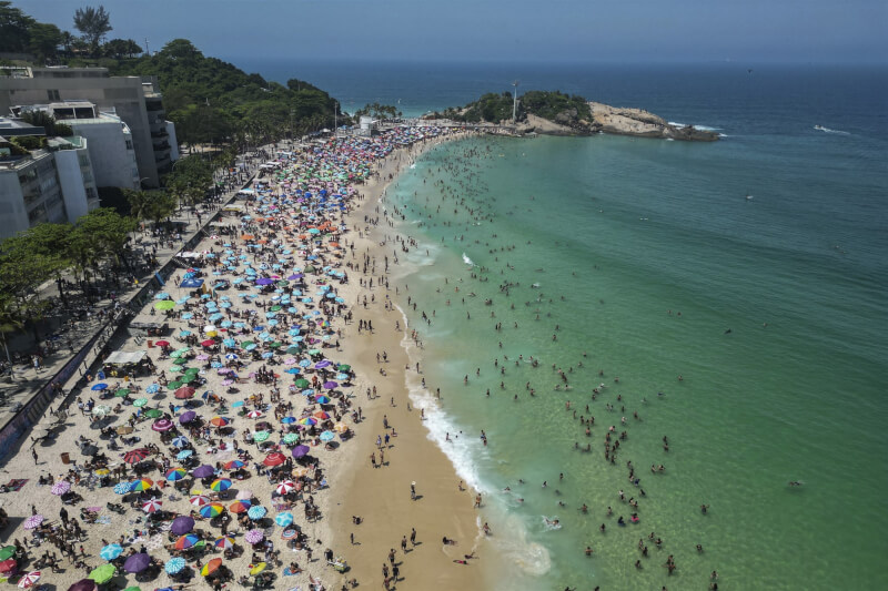巴西等南美多國今年冬天出現極端高溫，里約熱內盧的阿爾波多爾海灘24日擠滿「避暑」遊客。（美聯社）
