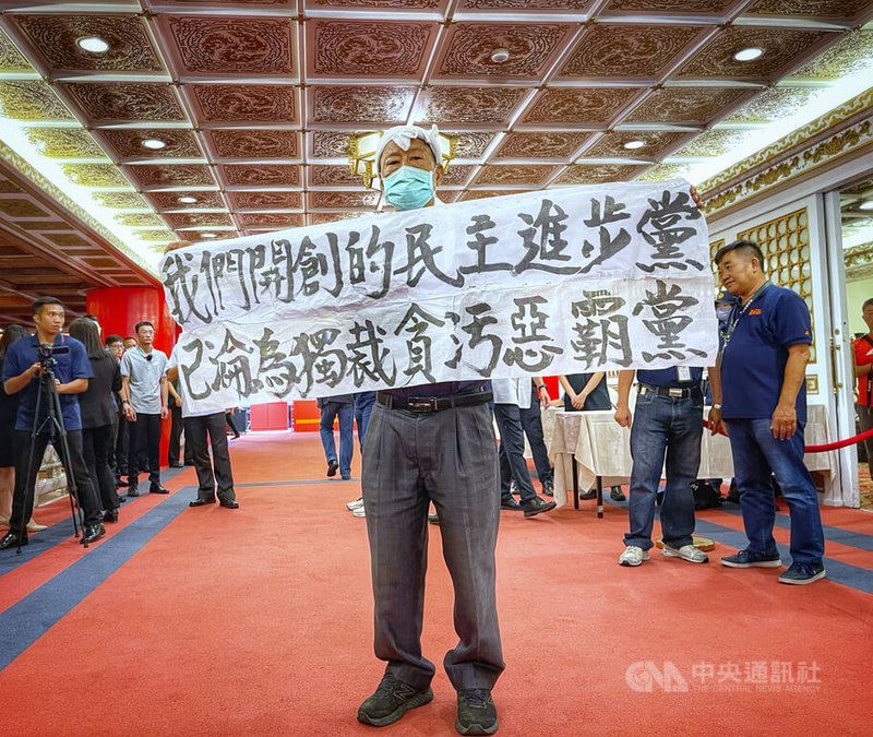 「民主進步黨37週年黨慶創黨先進聯誼餐會」27日台北圓山大飯店舉行,民進黨創黨元老、前立委魏耀乾(中)在場外拉布條抗議。中央社記者王飛華攝 112年9月27日