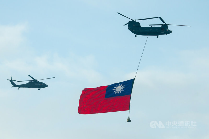 CH-47SD契努克運輸直升機（右）吊掛巨幅國旗、UH-60M黑鷹直升機（左）伴飛。中央社記者王騰毅攝 112年9月28日