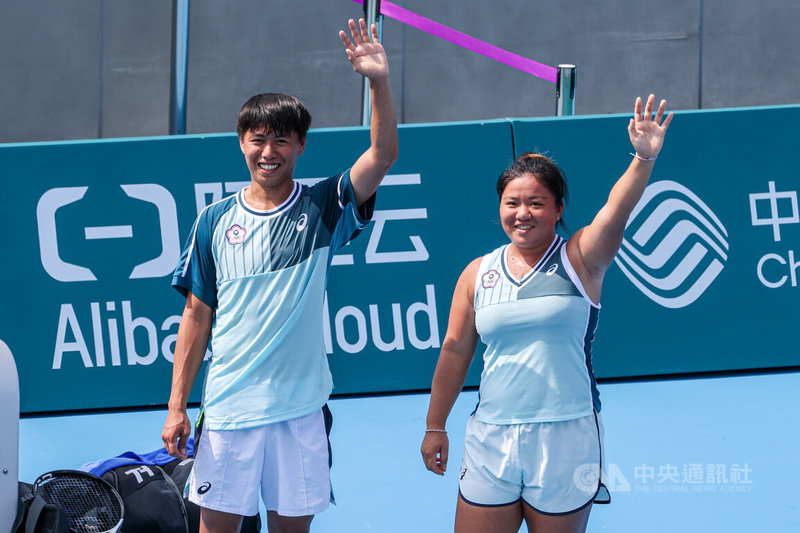 台灣網球選手梁恩碩（右）、黃琮豪（左）29日出戰杭州亞運網球混雙4強賽，最終以7比5、6比3獲勝，賽後兩人在場中向眾人揮手致意。中央社記者鄭清元攝 112年9月29日