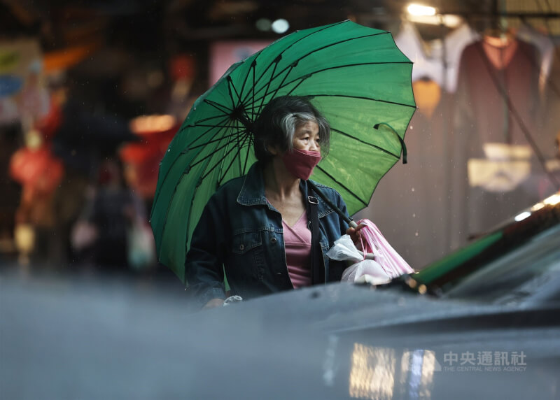 圖為新北市土城區民眾撐傘過馬路。（中央社檔案照片）