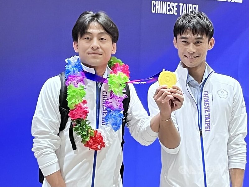 楊勇緯（右）在杭州亞運男子柔道60公斤級決賽奪下隊史首金，他返台時把金牌掛在哥哥楊俊霆身上，象徵分享努力成果。中央社記者葉臻攝 112年9月29日