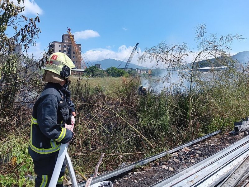 新北市八里文昌五街一處空地29日疑因周邊宮廟活動不慎引燃雜草導致火警，所幸未釀人員傷亡。消防局30日表示，將約談廟方相關人員了解案情，若查證屬實會依法舉發、裁罰。（翻攝畫面）中央社記者黃旭昇新北市傳真  112年9月30日