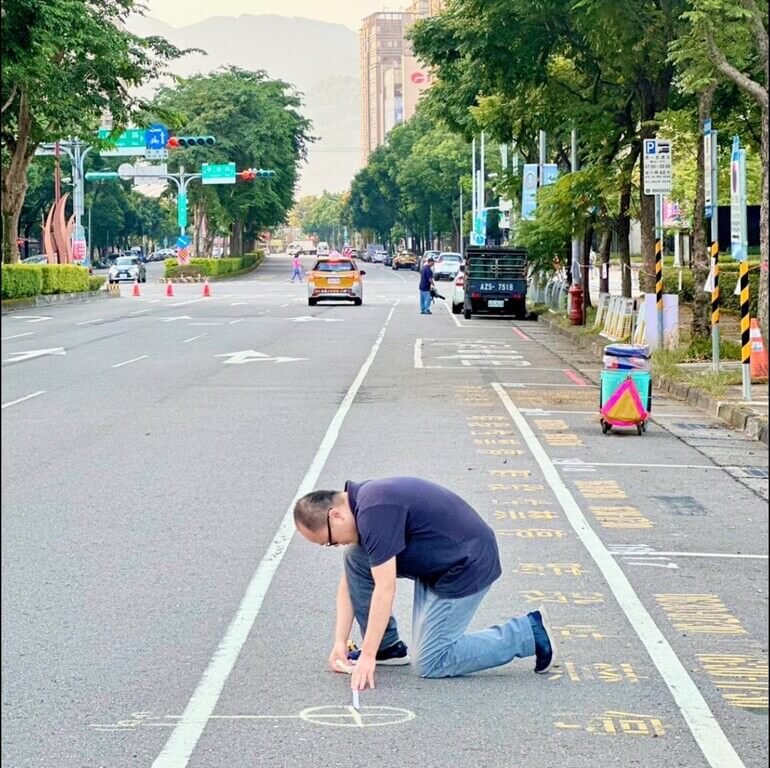 台灣交通安全協會副理事長林志學（前）具工程背景，也懂得國外先進的道路設計方法，他在一次新北市交安宣導活動中實際到場量測，繪製活動期間台北大學校門口公車行駛的安全標線與人行空間。（林志學提供）中央社記者汪淑芬傳真  112年10月1日