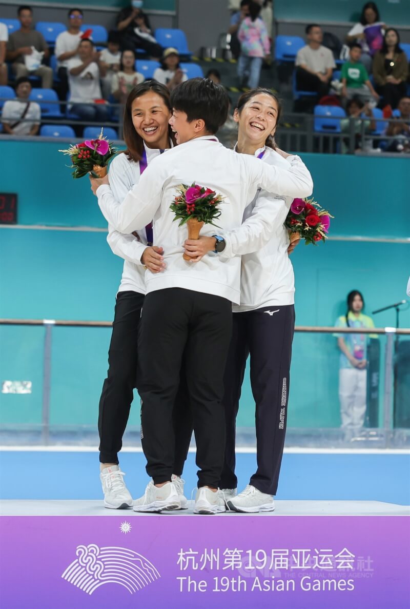 亞運滑輪溜冰競速溜冰3000公尺接力賽2日登場，女子組劉懿萱（右）、李孟竹（左）、楊合貞（中）勇奪本屆台灣第10金，3人在頒獎台上擁抱慶祝。中央社記者裴禛攝 112年10月2日