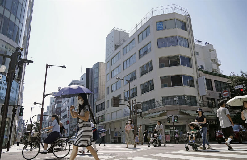 圖為日本靜岡市民眾撐傘遮陽。（共同社）