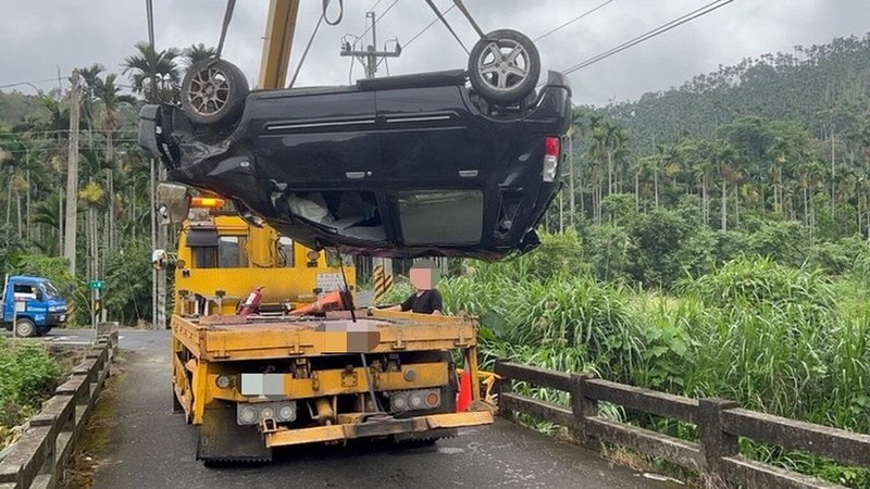 1輛黑色自小客車4日意外翻落嘉義縣中埔鄉忠全橋,四輪朝天躺在溪床上,駕駛雖無大礙但酒測值超標;警方獲報到場叫來吊車,協助將車輛吊離。(警方提供)中央社記者蔡智明傳真 112年10月4日