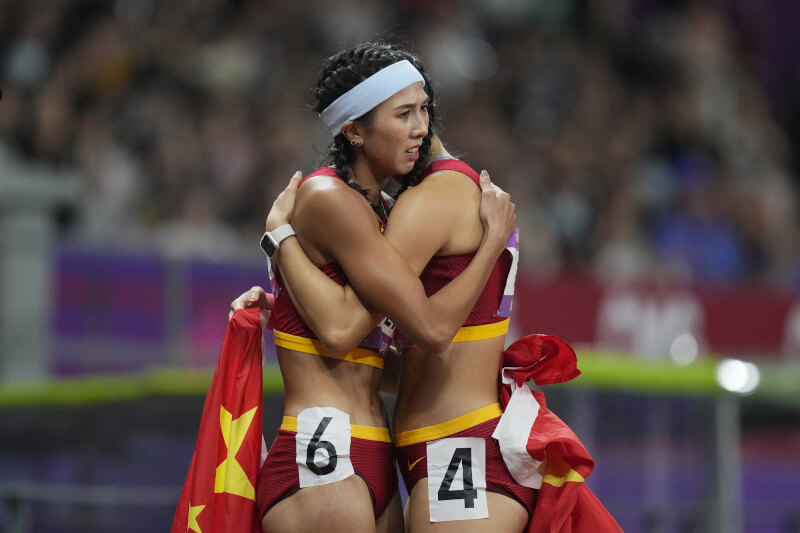 杭州亞運田徑賽事，女子100公尺跨欄中國選手吳艷妮和林雨薇賽後相擁，編號6號與4號同時入鏡觸動中共禁忌，圖像隨後被禁。（美聯社）