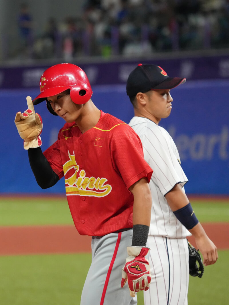 日本隊3日以0比1遭中國隊完封，中國首度在亞運棒球賽擊敗日本，梁培（左）為中國隊敲出致勝分。（中新社）