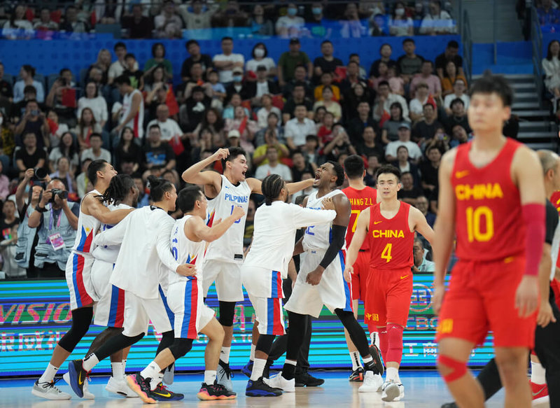 菲律賓（白方）5日在杭州亞運男子籃球準決賽以77比76一分之差，逆轉擊敗尋求衛冕的中國隊後，球員興奮擁抱。菲律賓這次派出的是僅備戰12天的二軍。（中新社提供）中央社  112年10月5日