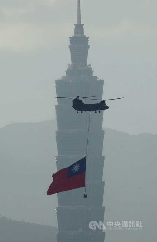 雙十國慶將至，國軍6日清晨展開國慶前最後一次空中全兵力預演，一架CH-47SD契努克運輸直升機吊掛巨幅國旗飛越台北市上空。中央社記者趙世勳攝 112年10月6日