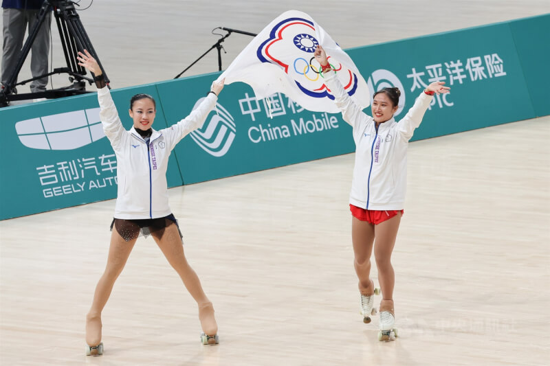 台灣好手洪筱晴（右）7日在杭州亞運滑輪花式溜冰女子決賽以總分94.38分摘金，張緻如（左）則以總分79.51分獲得銅牌，兩人賽後舉起中華奧會旗幟繞場致意。中央社記者裴禛攝　112年10月7日