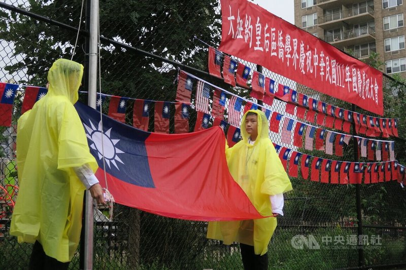 紐約市皇后區僑界7日在雨中舉行雙十國慶升旗典禮，僑務委員會海外青年文化大使協會（FASCA）學員擔任的旗手身穿雨衣。中央社記者尹俊傑紐約攝  112年10月8日