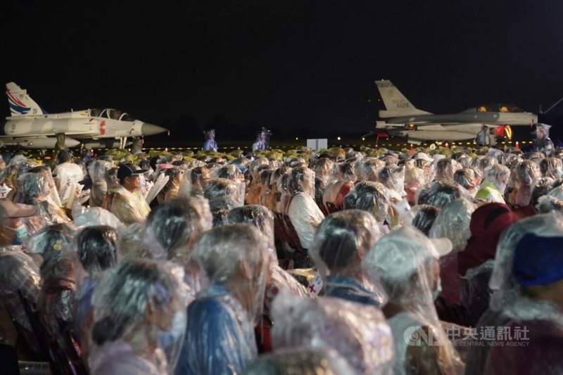 「民主台灣．堅韌永續」112年國慶晚會8日在空軍台南基地盛大舉行，晚間現場一度下起不小雨勢，民眾穿起雨衣參與盛會。中央社記者董俊志攝  112年10月8日