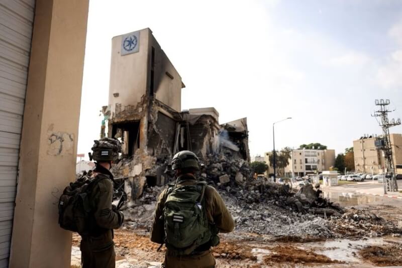 以色列警察8日站在一棟因受攻擊而成為廢墟的警察局旁。（路透社）