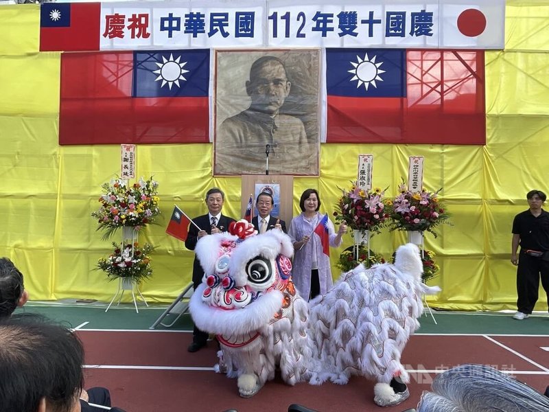 留日橫濱華僑總會10日舉辦國慶典禮,僑胞高唱國歌。典禮由舞獅表演揭開序幕,充滿喜慶氣氛。圖為橫濱華僑總會會長許耀庚(左)、駐日代表謝長廷(中)、橫濱辦事處處長張淑玲(右)出席典禮。中央社記者楊明珠橫濱攝 112年10月10日