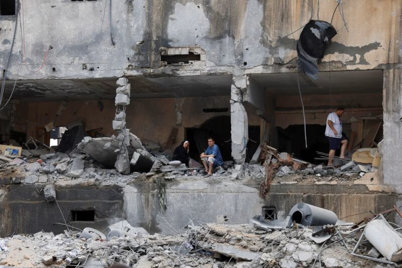 圖為以色列反擊哈瑪斯，對加薩走廊大規模空襲，巴勒斯坦民眾10日坐在一棟受損住宅中。（路透社）