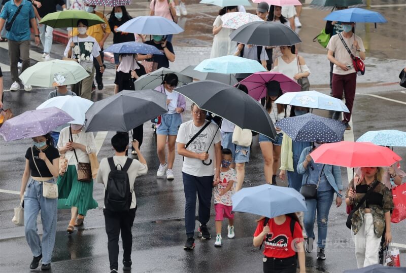 圖為台北市中山區街頭民眾撐傘過馬路。（中央社檔案照片）