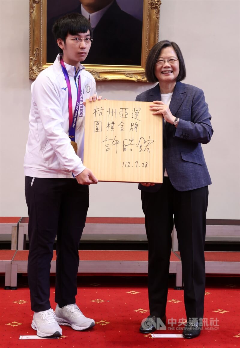 總統蔡英文(右)12日在總統府接見「第19屆杭州亞洲運動會」台灣代表團,奪得亞運圍棋首金的選手許皓鋐(左)代表回贈蔡總統金牌棋盤。中央社記者鄭傑文攝 112年10月12日