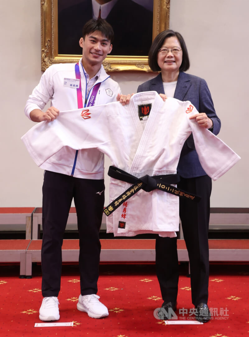 總統蔡英文(右)12日在總統府接見「第19屆杭州亞洲運動會」台灣代表團,亞運柔道金牌選手楊勇緯(左)代表回贈蔡總統金牌道服。中央社記者鄭傑文攝 112年10月12日