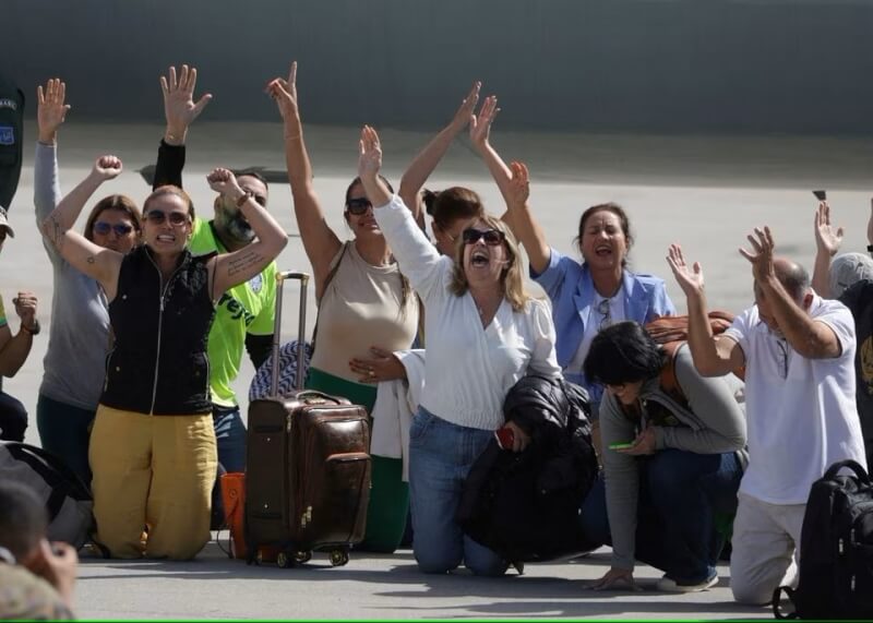 從以色列搭機抵達巴西的民眾11日在里約熱內盧機場跪地慶祝安全撤離。（路透社）