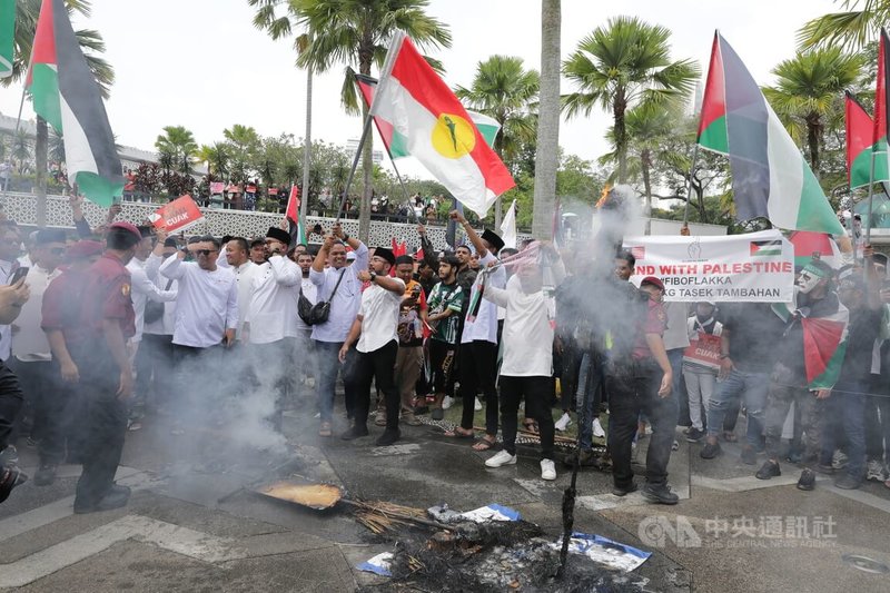 以巴衝突升級，馬來西亞團結青年組織13日下午在祈禱會後，發起支持和聲援加薩和巴勒斯坦人集會，現場並焚燒以色列國旗。中央社記者黃自強吉隆坡攝  112年10月13日